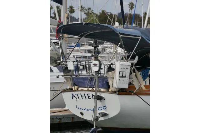 Slide: The Image of 1982 Cape Dory 36 sailboat docked, featuring a blue canopy and visible equipment. - 46