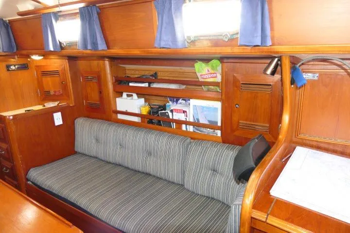 Slide: The Image of 1982 Cape Dory 36 yacht interior with striped sofa, wooden shelves, and nautical decor. - 9