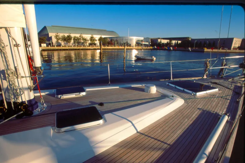 Slide: The Image of Deck view of a 2001 Baltic 52 yacht docked by a waterfront building. - 2