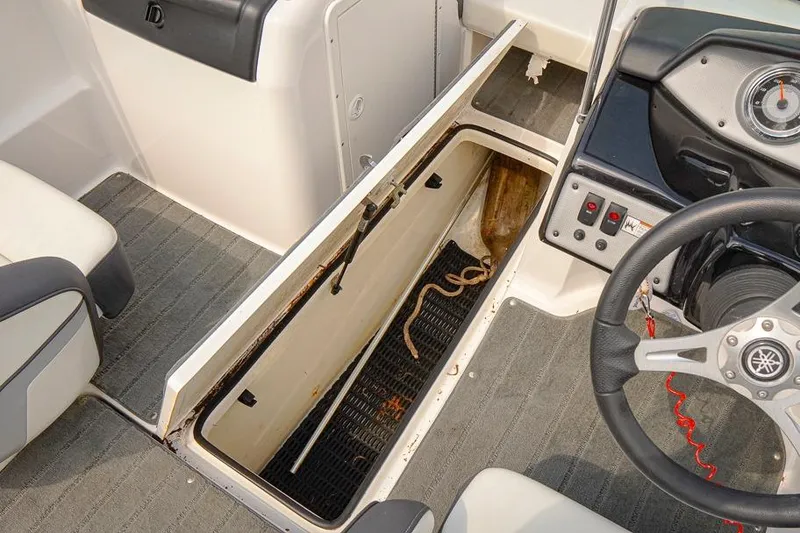 Slide: The Image of 2015 Yamaha Boats SX192 interior with open storage compartment and visible steering wheel. - 14