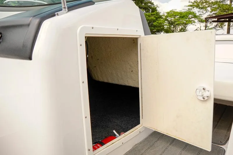 Slide: The Image of Open storage compartment on a 2015 Yamaha Boats SX192, featuring a fire extinguisher inside. - 15