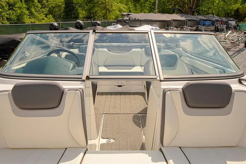Slide: The Image of 2015 Yamaha Boats SX192 interior with seating and windshield, parked outdoors. - 18