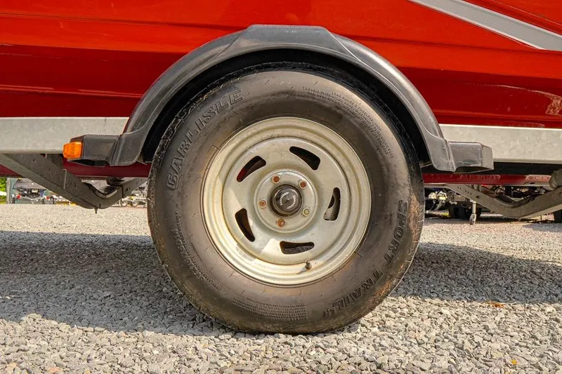 Slide: The Image of Trailer wheel of a 2015 Yamaha Boats SX192 on gravel surface. - 21