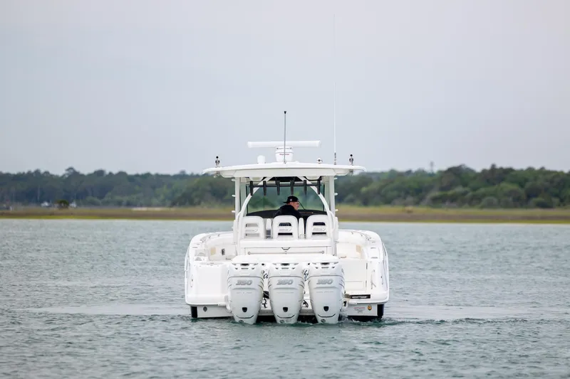 Slide: The Image of 2017 Boston Whaler 370 Outrage boat on water, rear view with triple engines. - 12