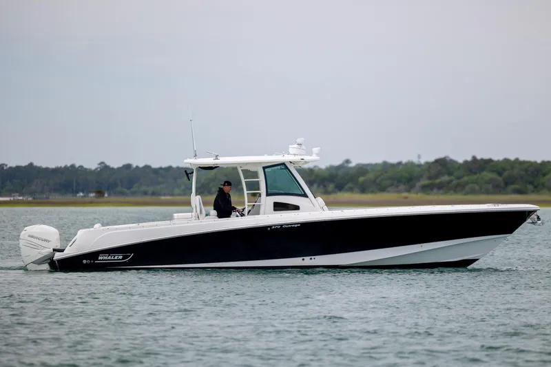 Slide: The Image of 2017 Boston Whaler 370 Outrage boat on water, side view with scenic background. - 15