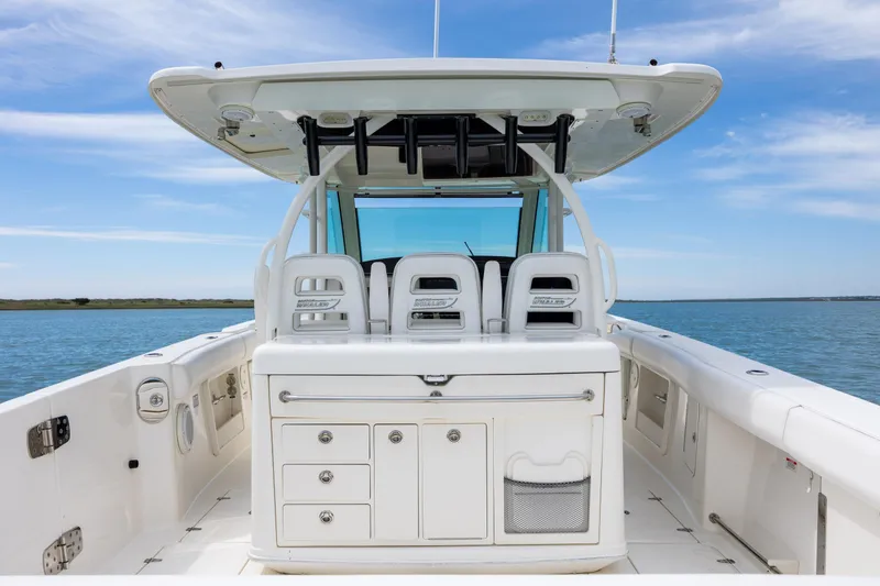 Slide: The Image of 2017 Boston Whaler 370 Outrage boat interior with seating and storage, on calm water. - 23
