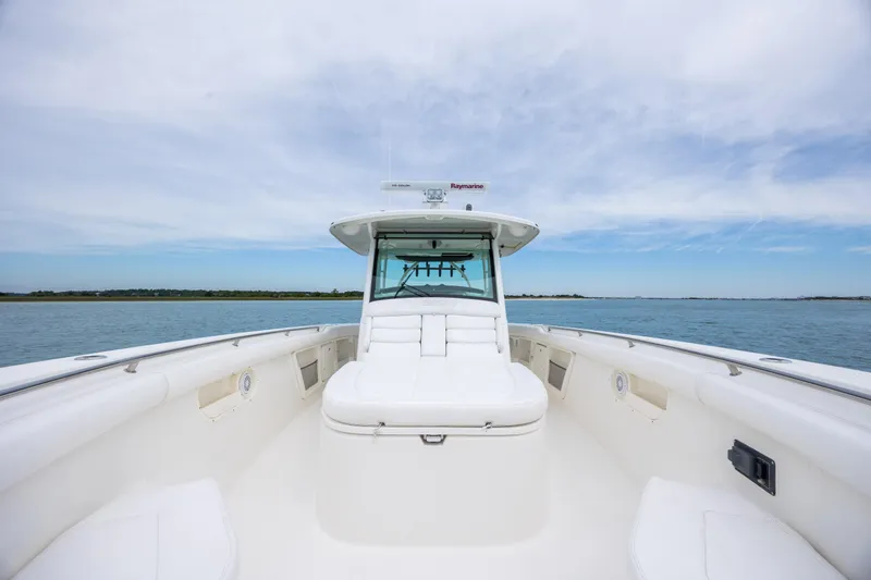 Slide: The Image of 2017 Boston Whaler 370 Outrage boat on calm water under blue sky. - 35