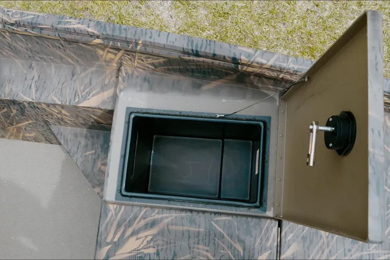 Slide: The Image of Open storage compartment on 2026 G3 Gator Tough 18 CC boat, featuring camo design. - 7