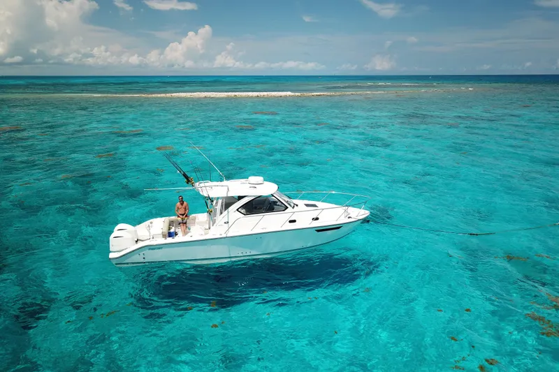 Slide: The Image of 2018 Pursuit OS 325 Offshore boat anchored in clear turquoise waters. - 10