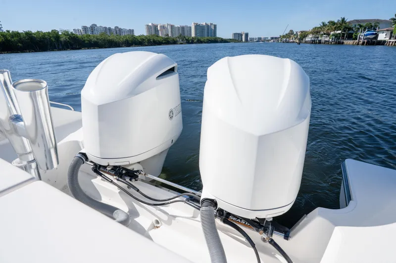 Slide: The Image of 2018 Pursuit OS 325 Offshore boat with dual outboard engines on a scenic waterway. - 13