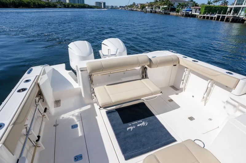 Slide: The Image of 2018 Pursuit OS 325 Offshore boat interior with seating, on a sunny day by the water. - 15