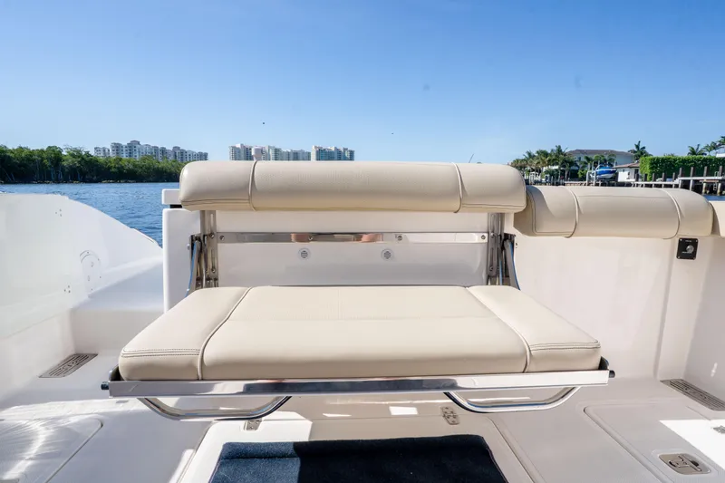 Slide: The Image of 2018 Pursuit OS 325 Offshore boat with beige seating, docked by waterfront. - 16