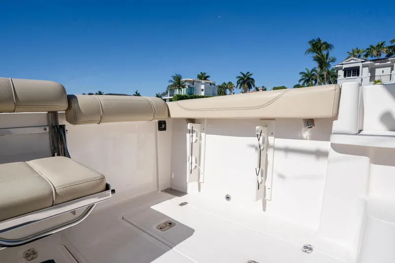Slide: The Image of 2018 Pursuit OS 325 Offshore boat interior with beige seating and clear blue sky. - 18
