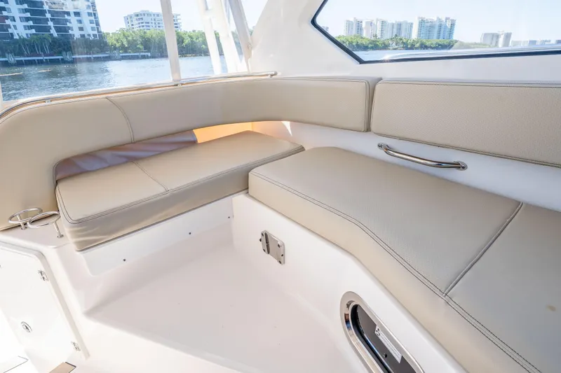 Slide: The Image of Interior seating of 2018 Pursuit OS 325 Offshore boat with waterfront view. - 22