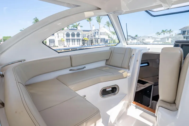 Slide: The Image of Interior of 2018 Pursuit OS 325 Offshore boat with beige seating and waterfront view. - 23