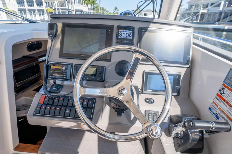 Slide: The Image of Helm of 2018 Pursuit OS 325 Offshore boat with advanced navigation controls and displays. - 25