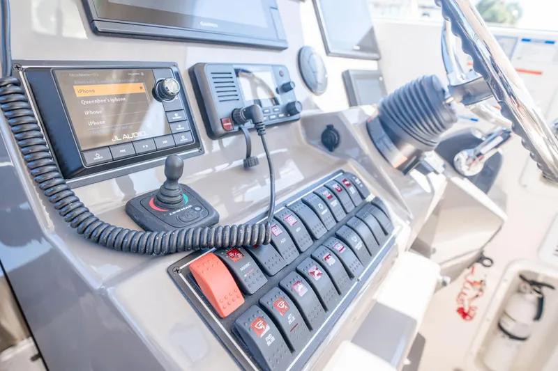 Slide: The Image of Control panel of a 2018 Pursuit OS 325 Offshore boat with audio system and switches. - 27