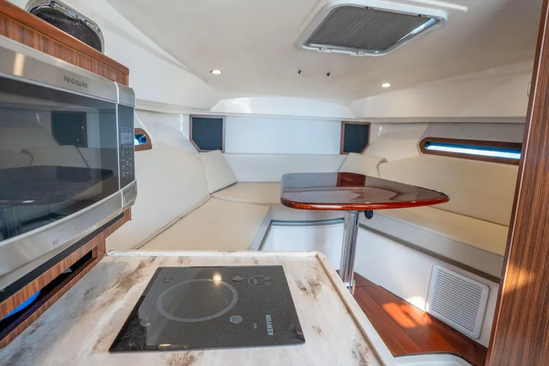 Slide: The Image of 2018 Pursuit OS 325 Offshore cabin interior with kitchenette and seating area. - 30