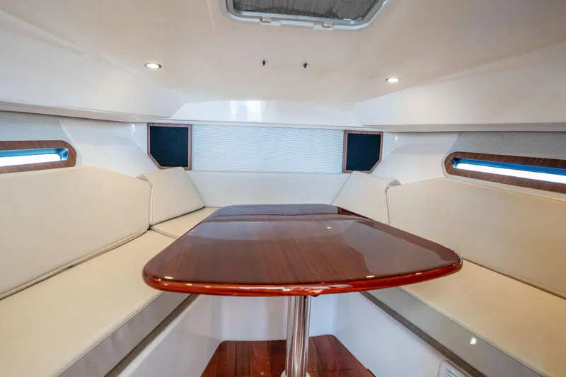 Slide: The Image of 2018 Pursuit OS 325 Offshore cabin with elegant seating and wooden table. - 35