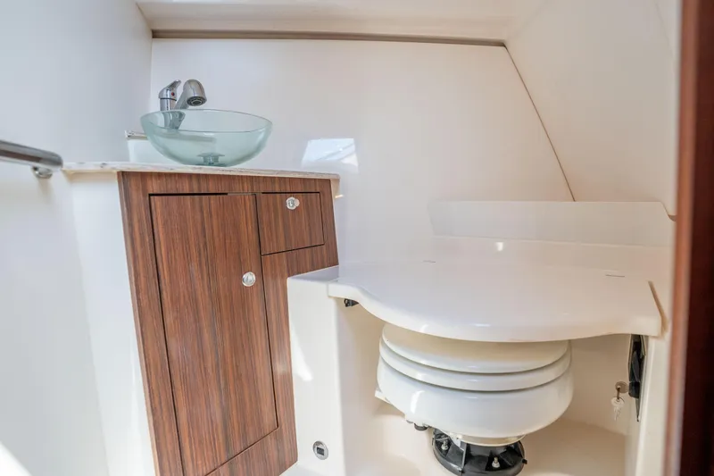 Slide: The Image of 2018 Pursuit OS 325 Offshore boat bathroom with modern sink and wooden cabinet. - 39
