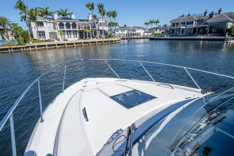 Slide: The Image of 2018 Pursuit OS 325 Offshore boat cruising near luxury waterfront homes. - 40