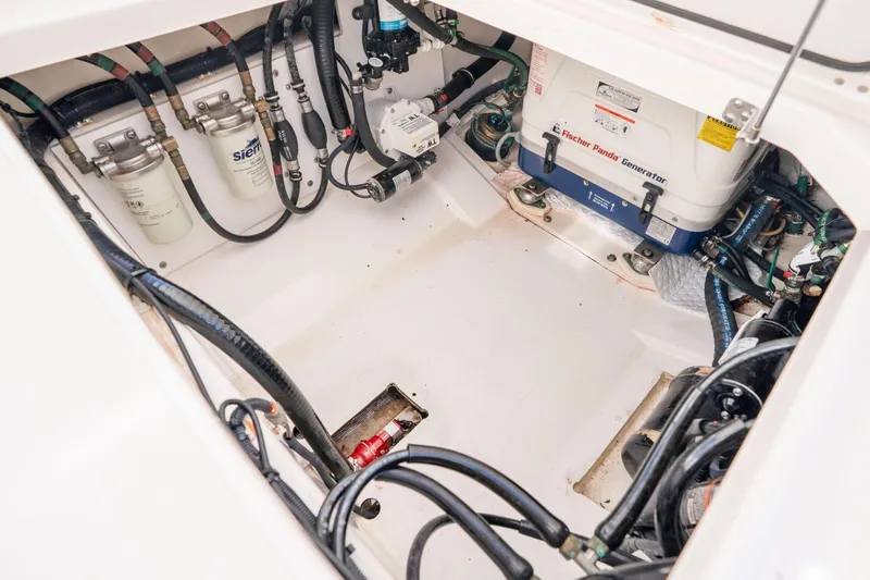 Slide: The Image of Engine compartment of a 2018 Pursuit OS 325 Offshore boat, featuring a Fischer Panda generator. - 45