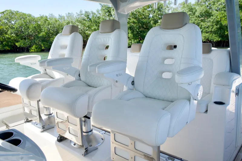 Slide: The Image of Luxurious white seating on 2019 HCB 53 Suenos boat, surrounded by lush greenery. - 35
