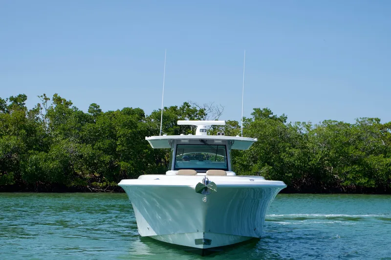 Slide: The Image of 2019 HCB 53 Suenos boat cruising on a serene waterway with lush greenery. - 4