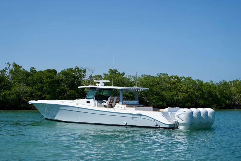 Slide: The Image of 2019 HCB 53 Suenos boat on calm water with lush greenery background. - 6