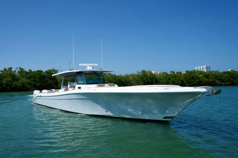 Slide: The Image of 2019 HCB 53 Suenos boat cruising on clear blue water, surrounded by greenery. - 8