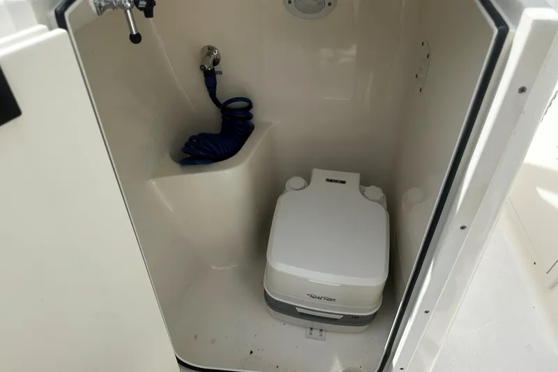 Slide: The Image of Interior of 2022 Key West 203 DFS boat with portable toilet and coiled hose. - 5