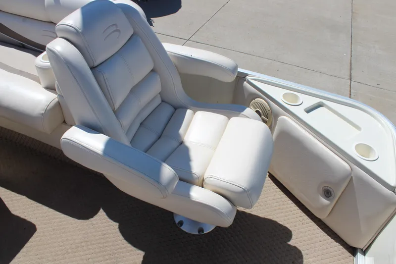 Slide: The Image of Luxurious white seating on a 2002 Bennington 2575FS boat, featuring cup holders and armrests. - 13