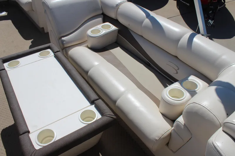 Slide: The Image of 2002 Bennington 2575FS boat interior with white cushioned seating and cup holders. - 16