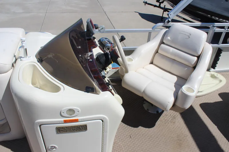 Slide: The Image of Captain's chair and console of a 2002 Bennington 2575FS boat, featuring a sleek design. - 18