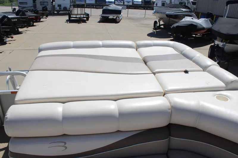 Slide: The Image of 2002 Bennington 2575FS boat with cushioned seating, displayed outdoors. - 22