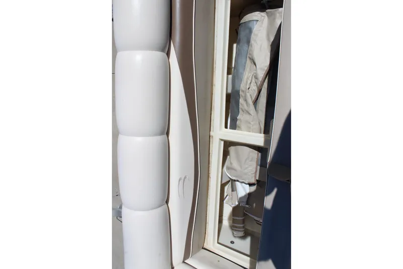 Slide: The Image of 2002 Bennington 2575FS boat interior storage compartment with beige upholstery. - 26
