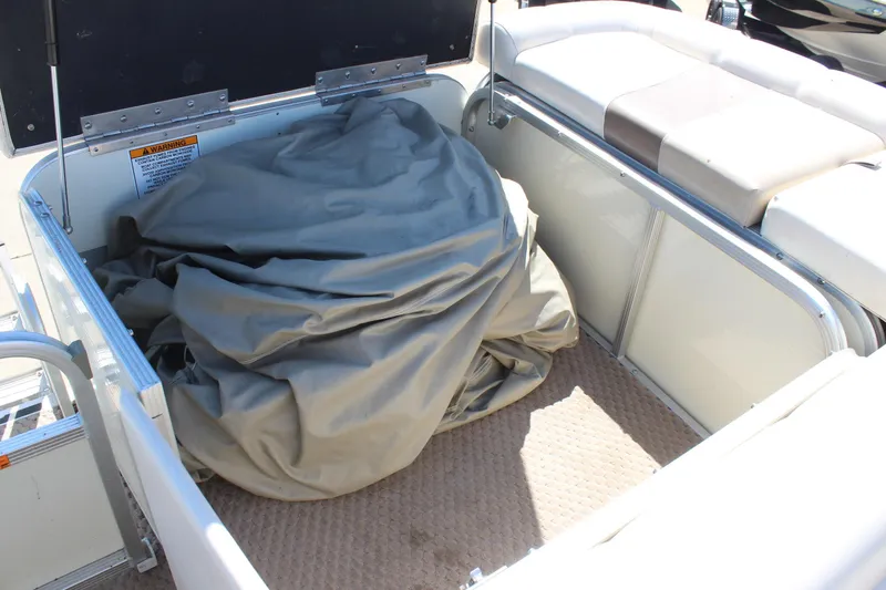 Slide: The Image of Storage compartment on a 2002 Bennington 2575FS boat with a folded cover inside. - 9