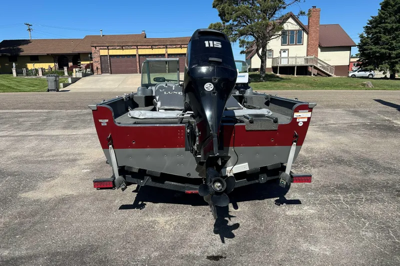 Slide: The Image of 2013 Lund 1775 Impact XS boat with 115 HP motor, parked in residential area. - 2