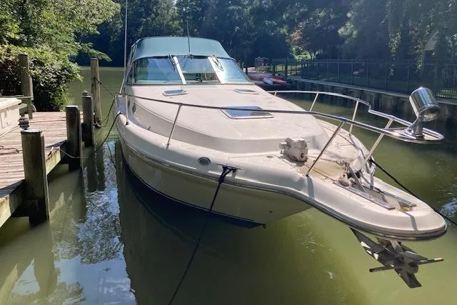 Slide: The Image of 1994 Sea Ray 290 Sundancer docked on a calm, tree-lined waterway. - 10