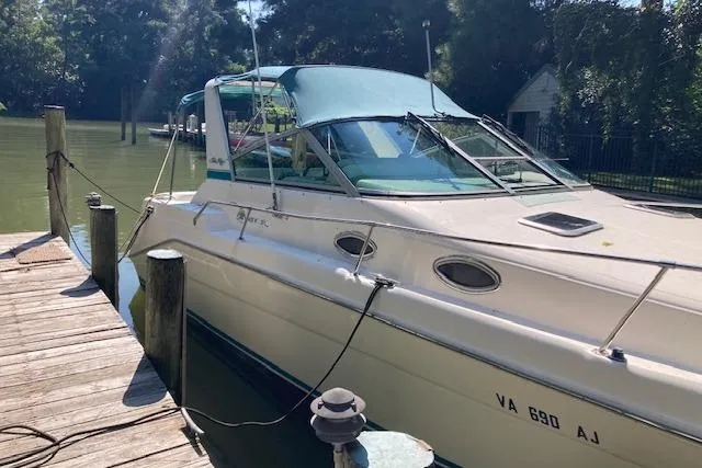 Slide: The Image of 1994 Sea Ray 290 Sundancer docked by a serene waterfront. - 7