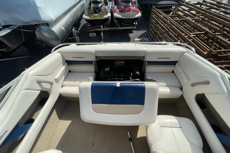 Slide: The Image of 1999 Chaparral 1830 SS boat interior with white and blue seating, engine compartment open. - 16