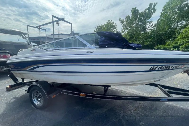 Slide: The Image of 1999 Chaparral 1830 SS boat on trailer, parked outdoors under cloudy sky. - 3