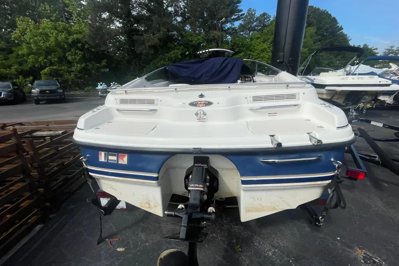 Slide: The Image of 1999 Chaparral 1830 SS boat, rear view, parked outdoors with trees in background. - 4