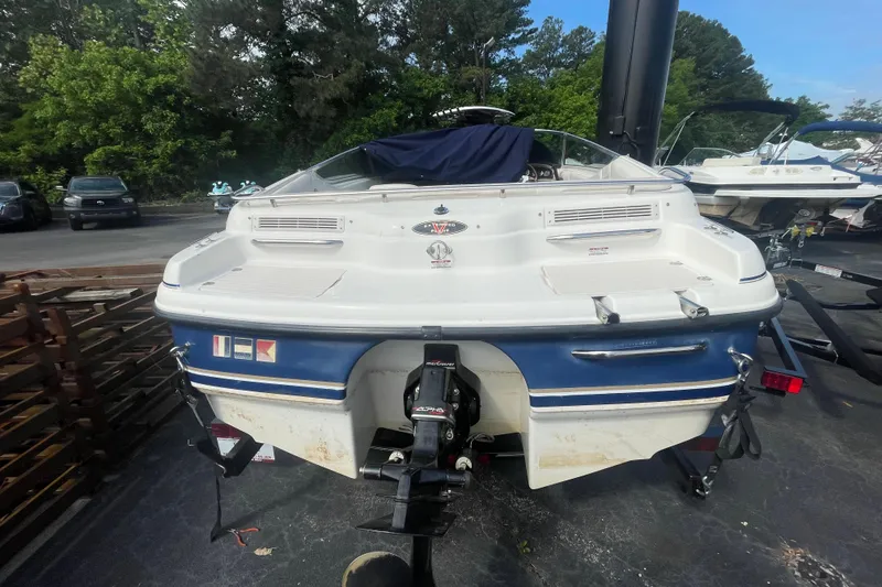 Slide: The Image of 1999 Chaparral 1830 SS boat, rear view, parked outdoors with trees in background. - 5