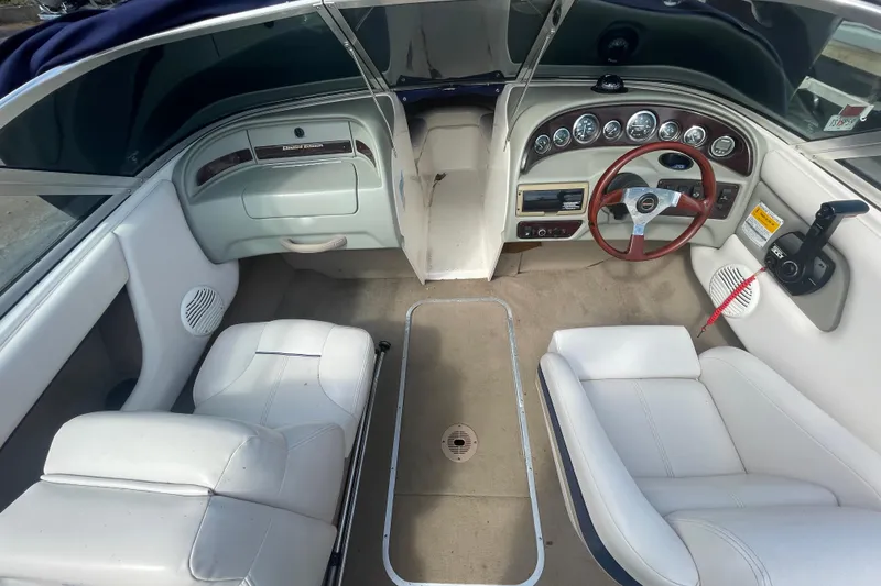 Slide: The Image of Interior of a 1999 Chaparral 1830 SS boat with white seating and dashboard. - 8