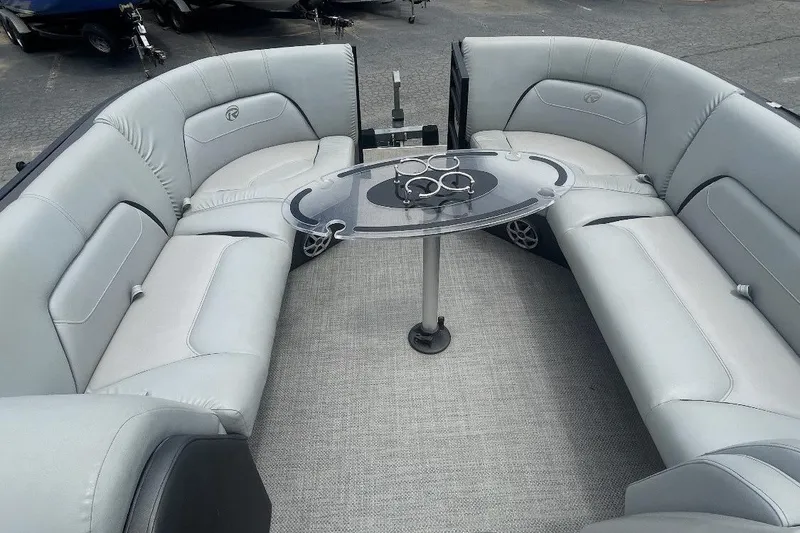 Slide: The Image of Luxurious seating area on a 2018 Lowe Retreat 250 RFL pontoon boat with a sleek table. - 2