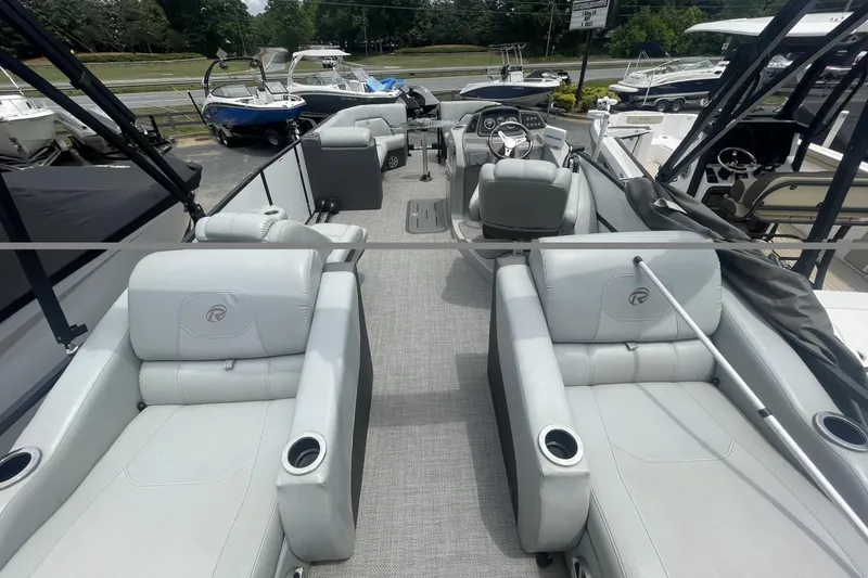 Slide: The Image of 2018 Lowe Retreat 250 RFL pontoon boat interior with plush seating and steering console. - 5