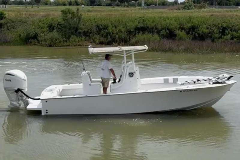 Slide: The Image of 2021 Latitude Tournament Boats 25 on calm water with a person at the helm. - 16