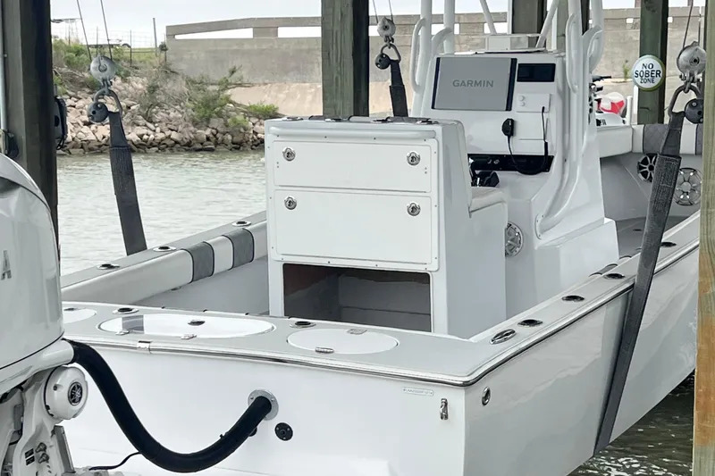 Slide: The Image of 2021 Latitude Tournament Boats 25, docked, featuring Garmin navigation system and sleek white design. - 5