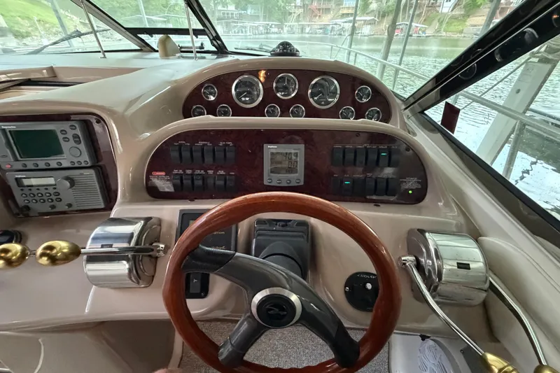 Slide: The Image of Cockpit of 2002 Sea Ray 360 Sundancer with steering wheel and control panel. - 13
